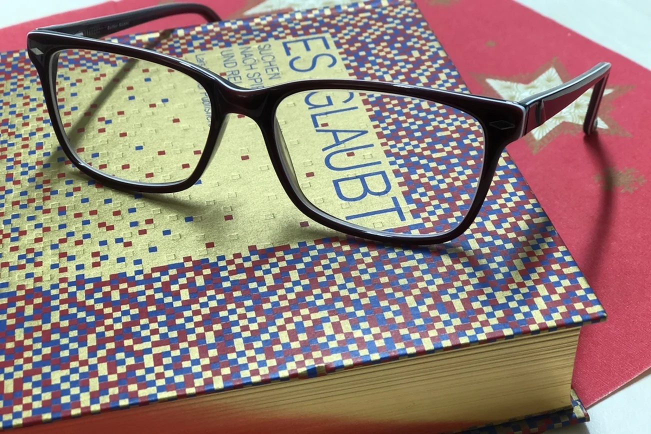 Ein Buch mit einer darauf liegenden Brille